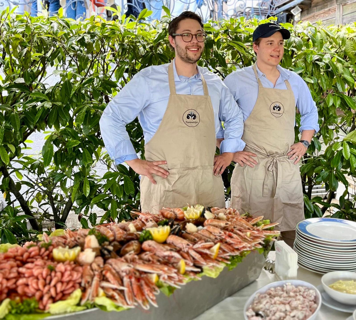 Tim and Joakim in aprons behind a Fiskskaldjur seafood platter