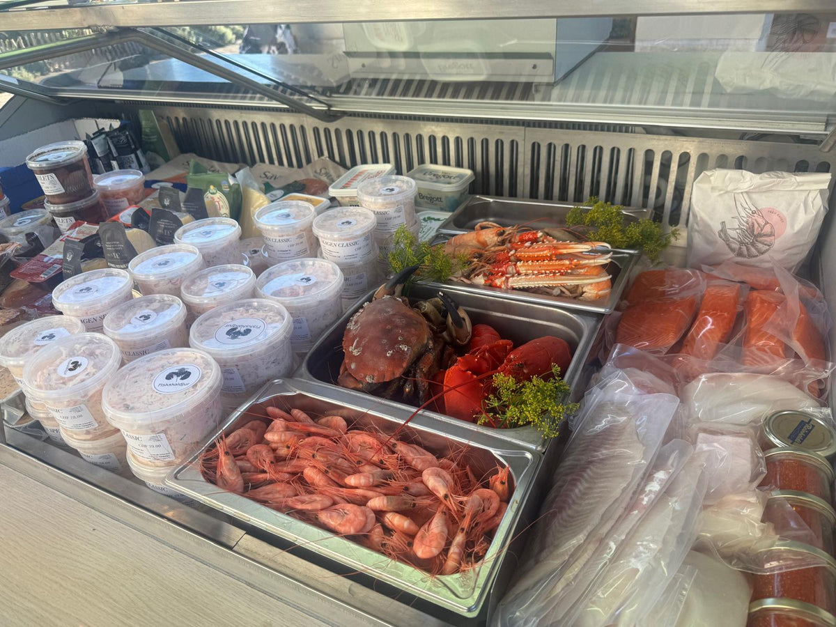 Langustinen, Taschenkrebs, Hummer, Crevetten, Lachs und Skagenröra in der Kühltheke am Markt in Morges